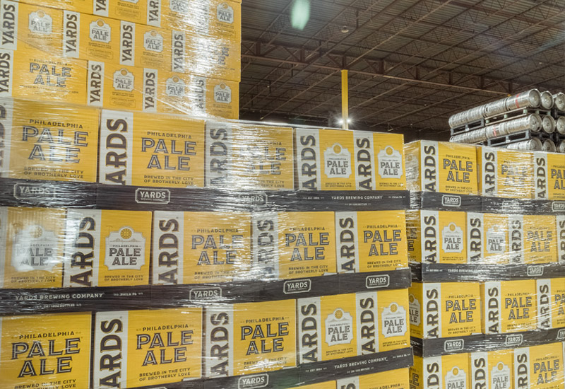 palettes of beer boxes stacked in a warehouse